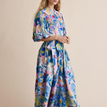 Woman wearing a colorful dress with abstract patterns on a beige background