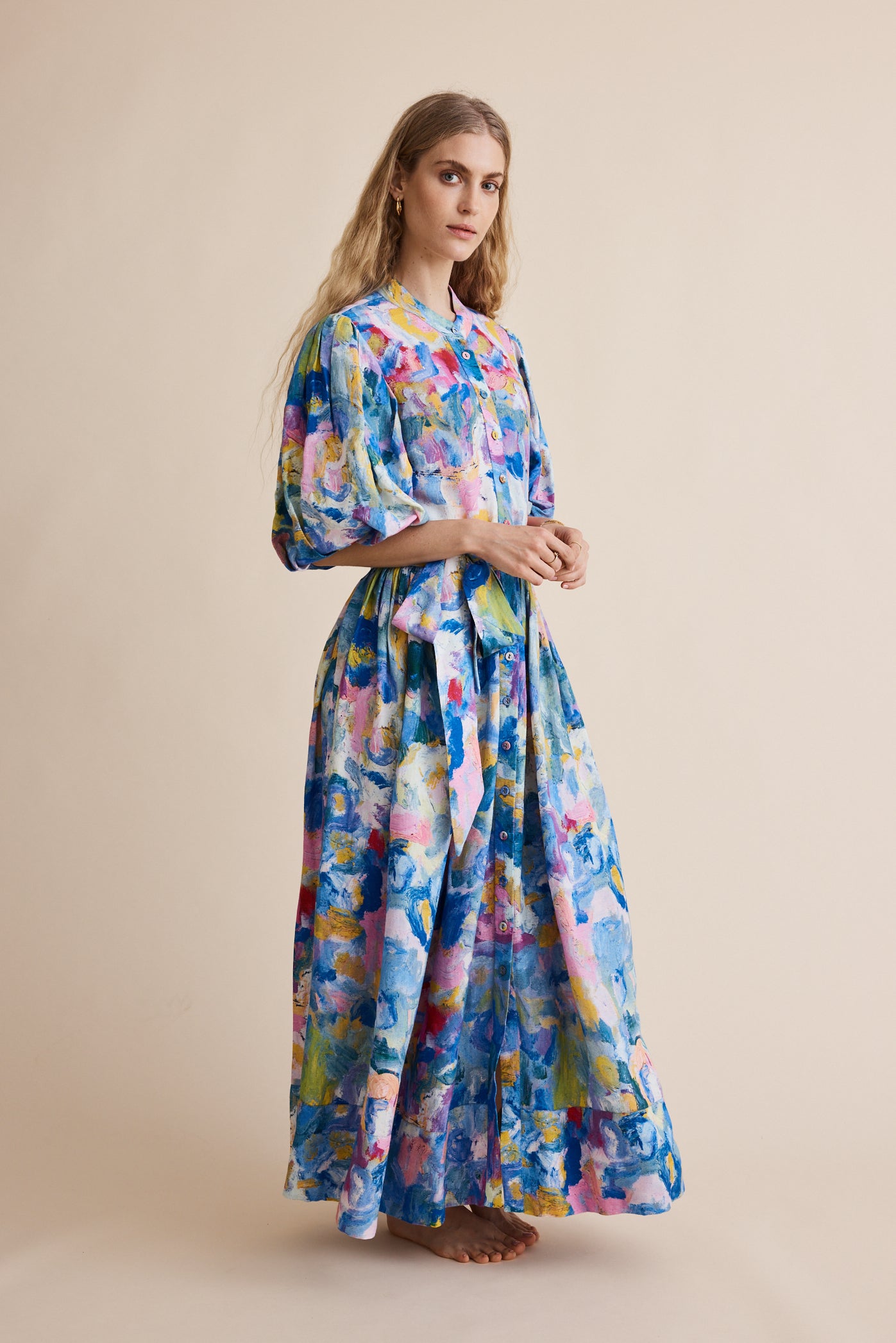 Woman wearing a colorful dress with abstract patterns on a beige background