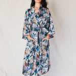 Woman wearing a floral robe against a plain background