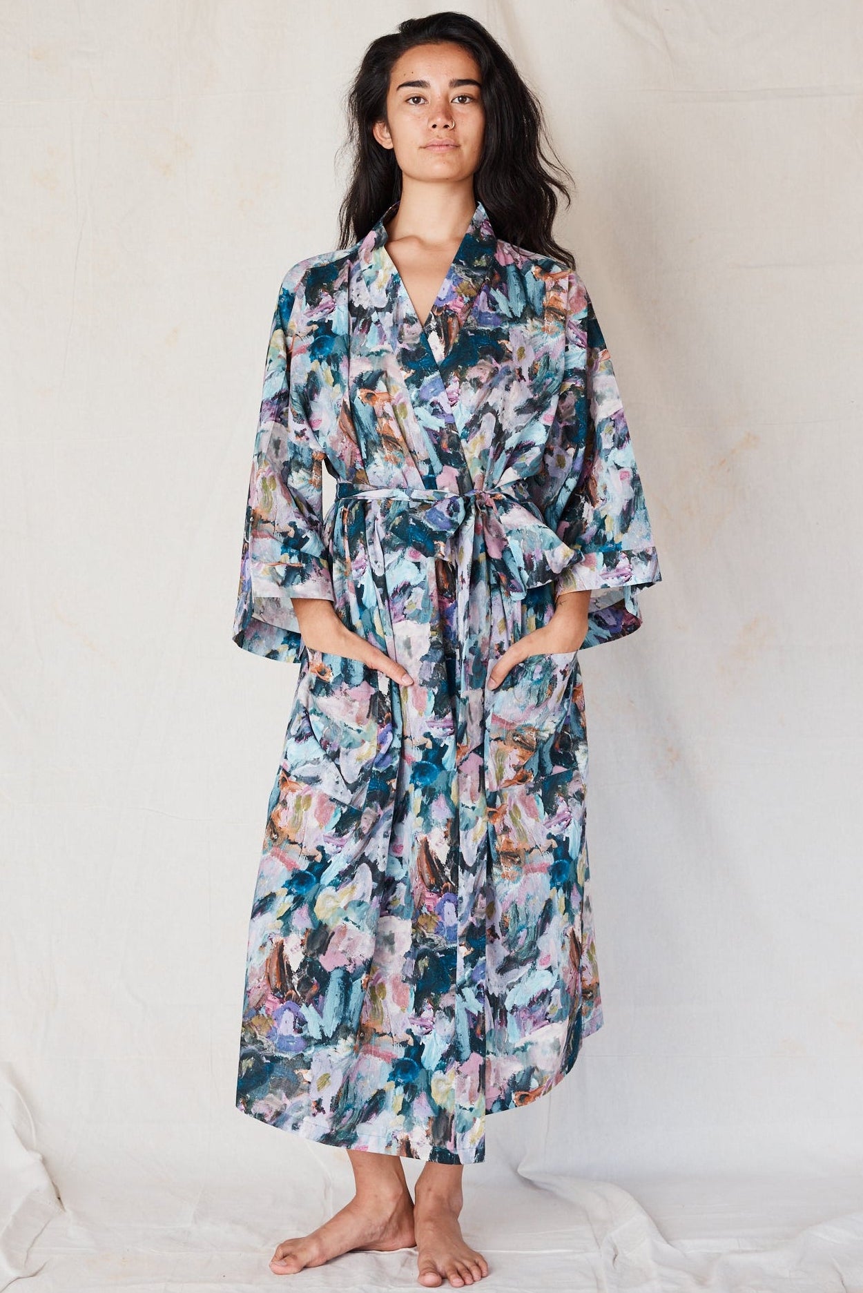 Woman wearing a floral robe against a plain background