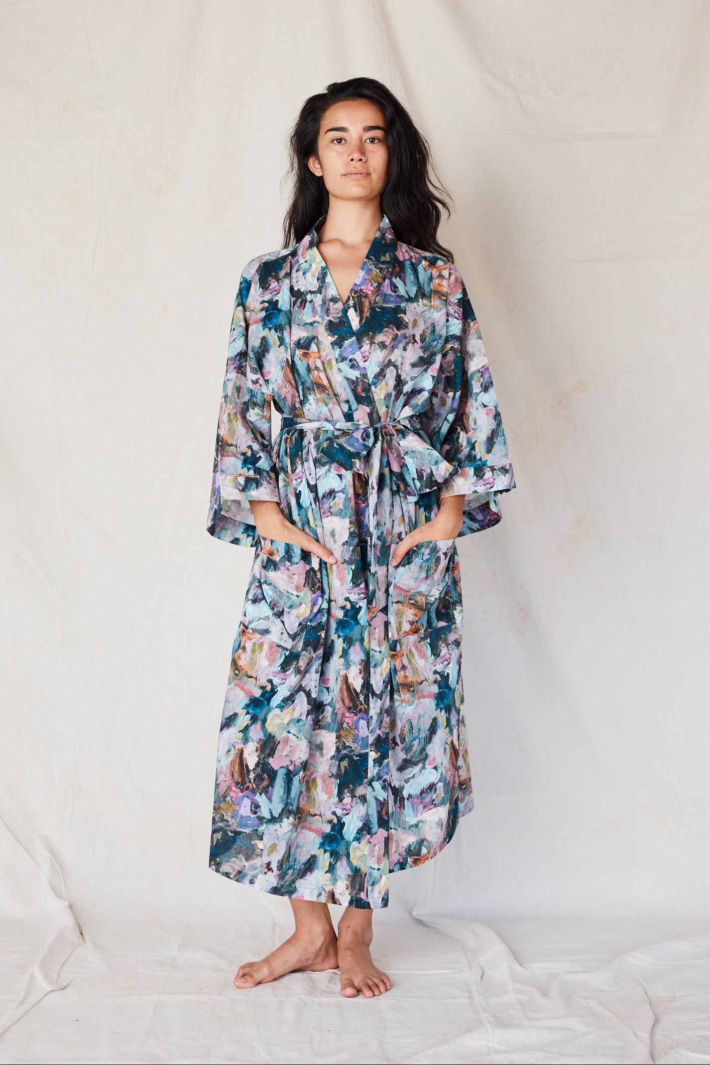 Woman wearing a floral robe against a plain background