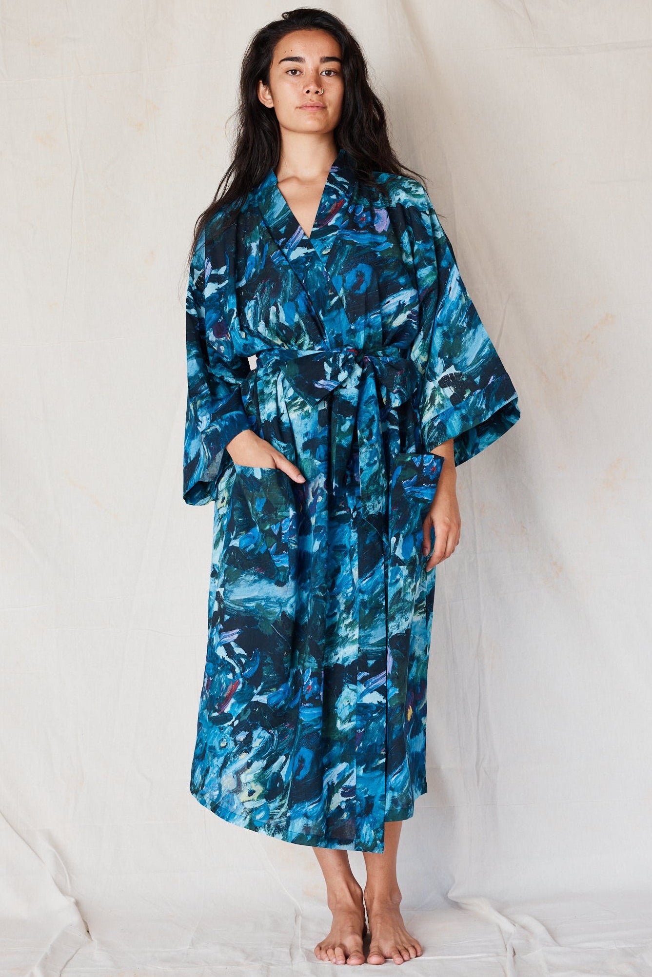 Woman wearing a blue floral patterned robe against a white background