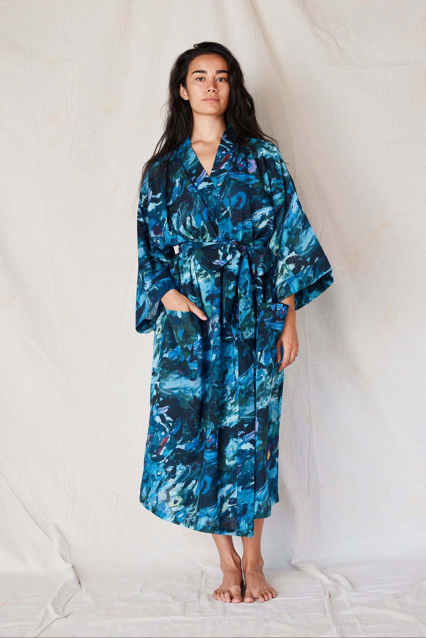 Woman wearing a blue floral patterned robe against a white background