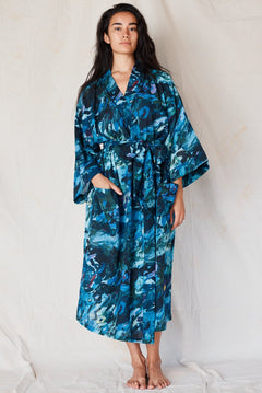 Woman wearing a blue floral patterned robe against a white background